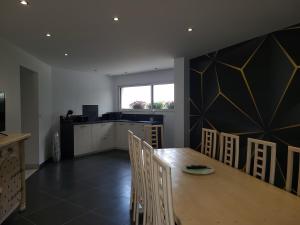 a kitchen and dining room with a table and chairs at L'escale Romanesque in Ozeville