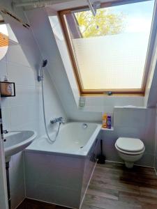 a bathroom with a toilet and a bath tub and a window at Apartment with parking in Berlin 11 in Berlin