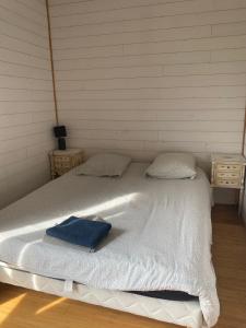 a white bed with a blue towel on it at Domaine des Ecuries vailley in Bouleurs