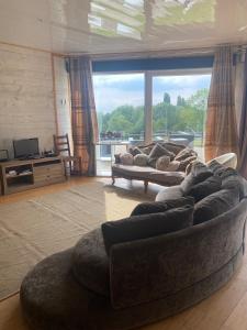 a living room with a couch and a large window at Domaine des Ecuries vailley in Bouleurs