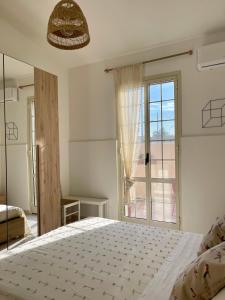 a bedroom with a bed and a large window at Villa Patty in Marzamemi