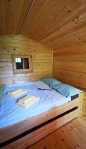 Bett in einem Holzzimmer in einem Blockhaus in der Unterkunft Krasen Kras 104 resort in Komen