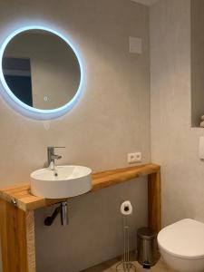 ein Bad mit einem Waschbecken und einem Spiegel in der Unterkunft EVEN Bistrot in Évenos