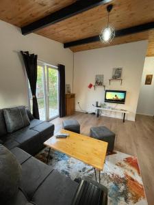 - un salon avec un canapé, une table et une télévision dans l'établissement Cozy Wooden House, à Durrës