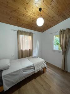una camera con letto e soffitto in legno di Cozy Wooden House a Durrës