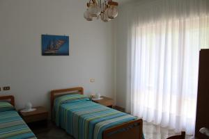 um quarto com 2 camas e uma janela com cortinas em B&B Il Melograno em Roccacasale