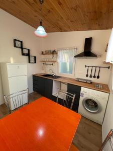 - une cuisine avec une table et un lave-linge dans l'établissement Cozy Wooden House, à Durrës