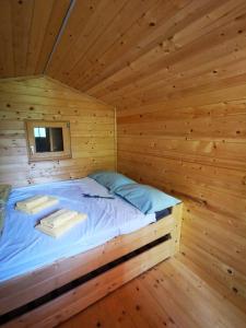 Cabaña de madera con cama en una habitación en Krasen Kras 104 resort en Komen