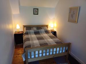 a bedroom with a bed with two lamps on two tables at Simonside Cottage nr Rothbury in Morpeth