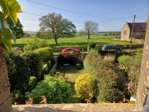 a garden with two cars parked in a yard at Simonside Cottage nr Rothbury in Morpeth
