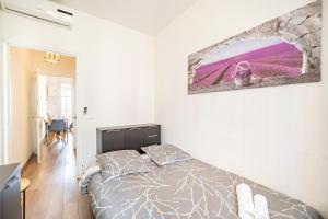 Un dormitorio con una cama y un cuadro en la pared. en 2mn de Monaco - Centre de Beausoleil - CH, en Beausoleil