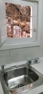 - un lavabo dans la cuisine avec une fenêtre au-dessus dans l'établissement Apartamento con vistas en el centro de Mojácar, à Mojácar