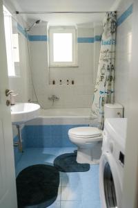 een badkamer met een toilet, een bad en een wastafel bij Stefanos apartment in Nafplio