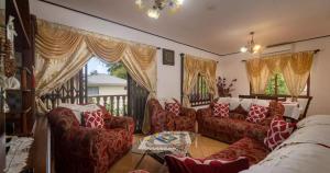 uma sala de estar com sofás vermelhos e uma varanda em Chez Benoit Self Catering em Victoria