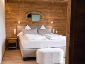 a white bed in a room with a mirror at Wellness Pension am Rain in Winden im Elztal +59 photos