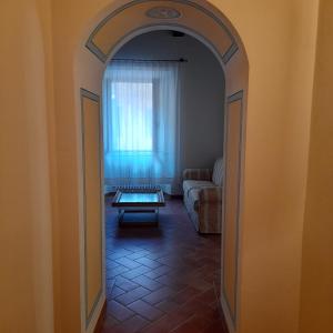 un arco que conduce a una sala de estar con sofá en La casa in piazza, en Panicale