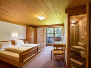 ein Schlafzimmer mit einem Bett und ein Badezimmer mit einem Waschbecken in der Unterkunft Bauernhof Niederfilzboden in Fieberbrunn