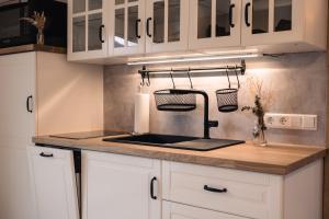 a kitchen with white cabinets and a sink at Wellness Pension am Rain in Winden im Elztal