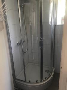 a shower with a glass door in a bathroom at Bed & Breakfast Klokgaaf in De Koog