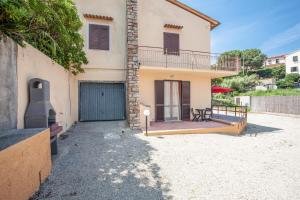 a house with a balcony and a patio at Villetta Capo Bianco - Goelba in Portoferraio