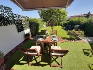 una mesa de madera y sillas en un jardín en Chalet en el centro de Baiona con vistas, en Baiona