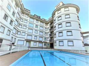 an apartment building with a swimming pool in front of it at Apartamento Welcome Grañamar in Sanxenxo