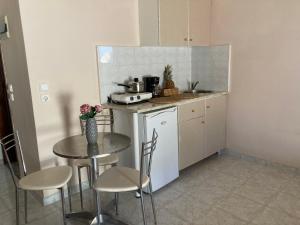 a small kitchen with a table and a table and chairs at SeaSide BayView in Faliraki