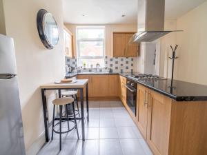a kitchen with wooden cabinets and a counter top at Beautiful 5 Guest Property with free parking in Nottingham
