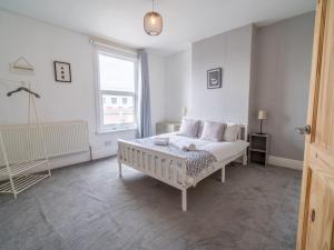 ein weißes Schlafzimmer mit einem Bett und einem Fenster in der Unterkunft Beautiful 5 Guest Property with free parking in Nottingham
