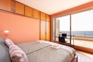 um quarto com uma cama e uma grande janela em Medano Seaview Penthouse CASA CORINA III em El Médano