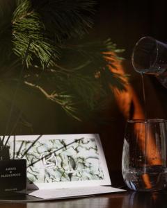 una mesa con un libro y un vaso de agua en Kerpė Hotel & SPA en Palanga