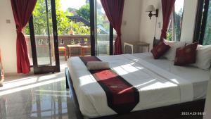 烏布的住宿－Yoga Homestay Ubud，一间带一张大床的卧室,位于带窗户的房间内