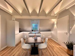 a dining room with a table and white chairs at DRIEHOF Panorama Apartment Apt 9 in Tecklenburg