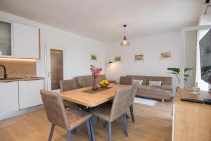 eine Küche und ein Wohnzimmer mit einem Holztisch und Stühlen in der Unterkunft Apartment Dina in Malinska + 25 Fotos