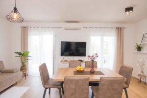 ein Wohnzimmer mit einem Esstisch mit Stühlen in der Unterkunft Apartment Dina in Malinska