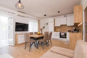 eine Küche und ein Esszimmer mit Tisch und Stühlen in der Unterkunft Apartment Dina in Malinska