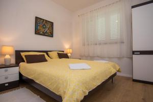 ein Schlafzimmer mit einem Bett mit gelber Tagesdecke in der Unterkunft Apartment Dina in Malinska