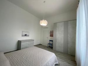 a bedroom with a white bed and a blue chair at Villa Rosy in San Vincenzo