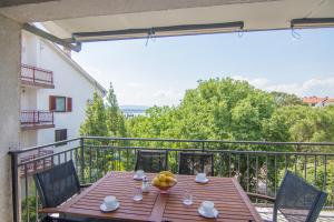 einen Holztisch mit einer Schale Bananen auf dem Balkon in der Unterkunft Apartment Dina in Malinska