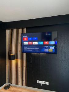 a flat screen tv hanging on a wall at Le Mayda - Parking Privé Gratuit in Marseille