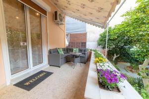 a patio with a couch and a table with flowers at LUXURY AND COMFORTABLE VILLA in Athens