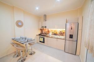 a kitchen with a table and a refrigerator at LUXURY AND COMFORTABLE VILLA in Athens