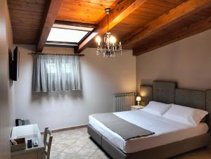 una camera con un grande letto e un lampadario a braccio di Bed & Breakfast De Nittis a Barletta