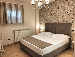 una camera con letto e lampadario a braccio di Bed & Breakfast De Nittis a Barletta