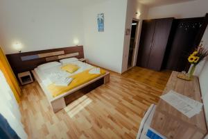 a small bedroom with a bed and a wooden floor at Complex Marinn Costinesti in Costinesti