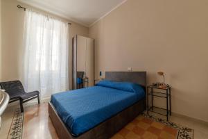 ein Schlafzimmer mit einem blauen Bett und einem Stuhl in der Unterkunft Functional Apartment - Piazza Re di Roma in Rom
