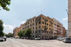 ein großes Gebäude in einer Stadtstraße mit parkenden Autos in der Unterkunft Functional Apartment - Piazza Re di Roma in Rom