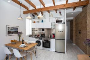 a kitchen with a table and a refrigerator at SingularStays Roger de Flor in Valencia