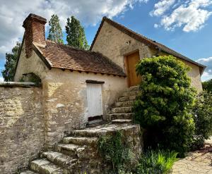uma antiga casa de pedra com escadas que levam a uma porta em Domaine de Couilleuse em Saint Laurent Nouan