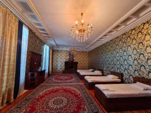 a room with four beds and a chandelier at May Weather Resort in Bukhara